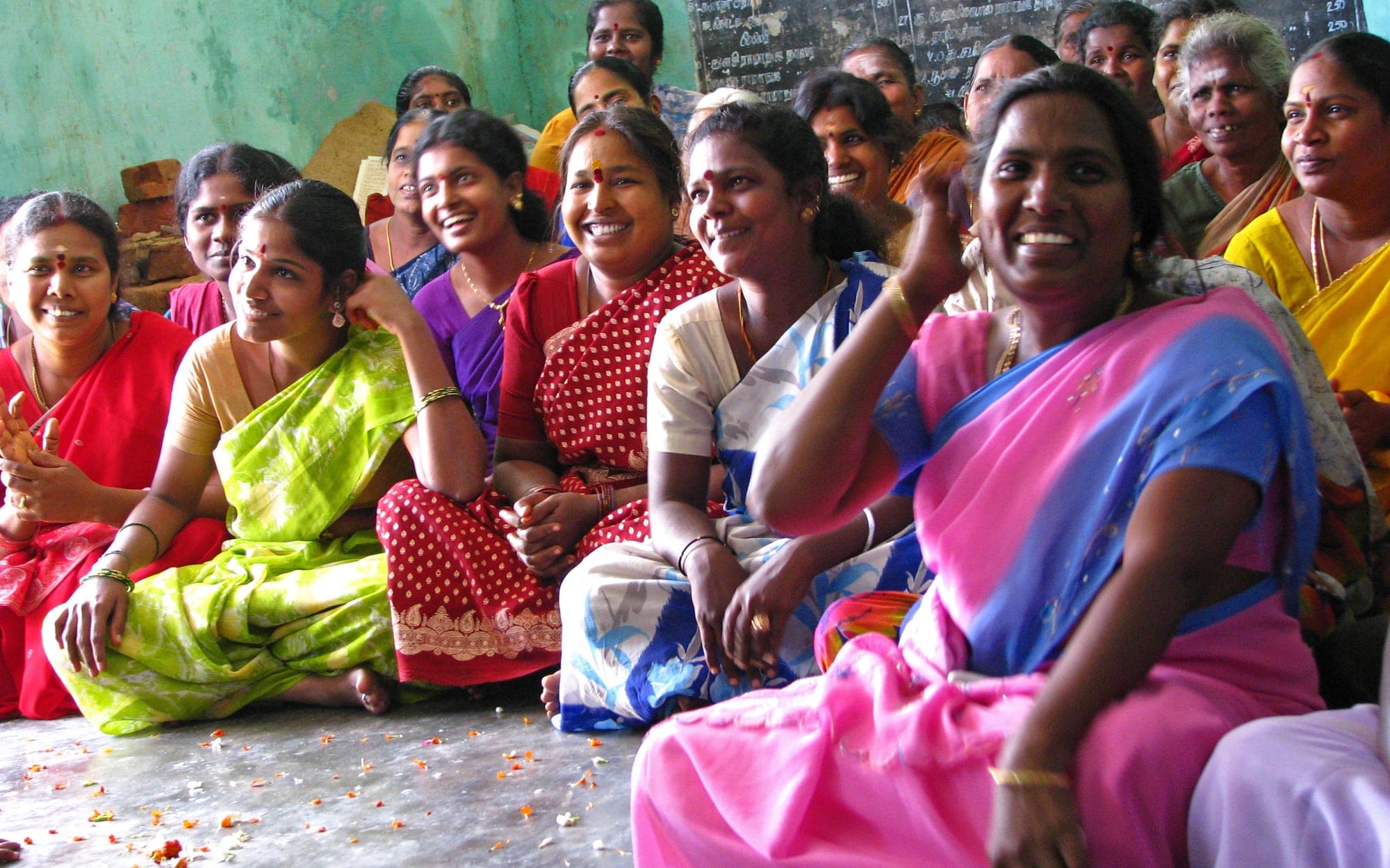 Women at a self-help group meeting in rural Tamil Nadu, smiling and talking