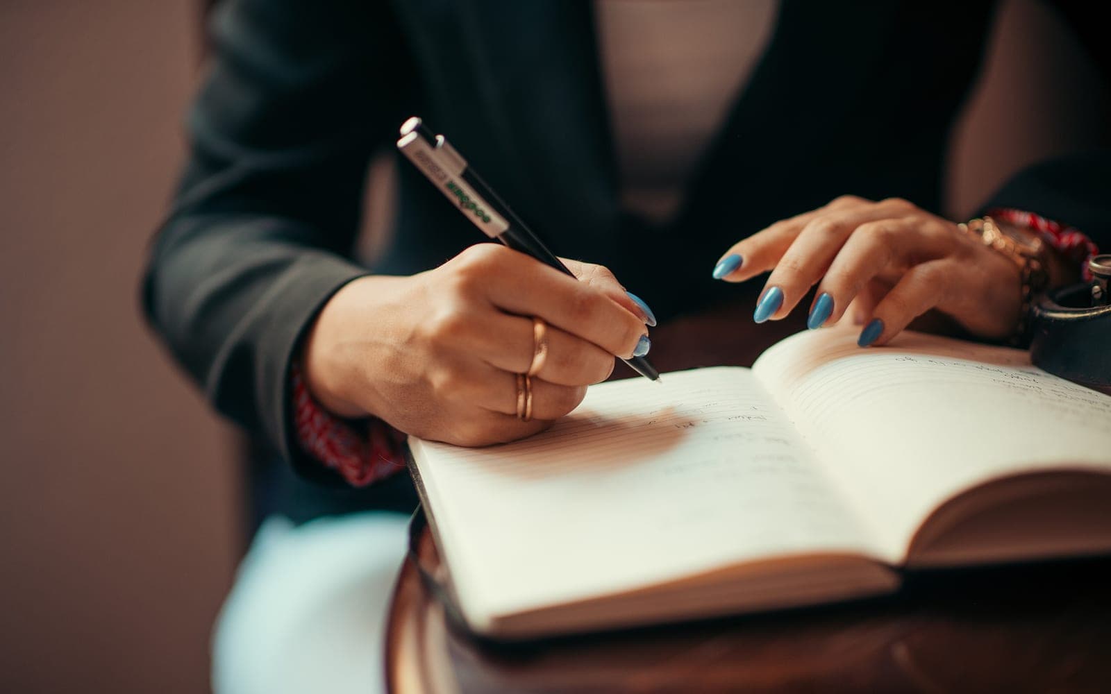 Close-up of hands writing notes in a notebook